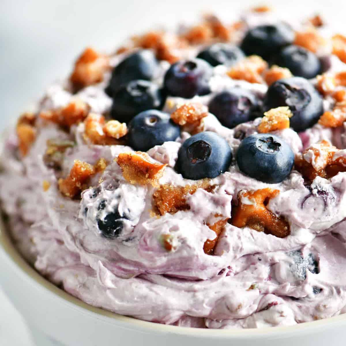 a white bowl of blueberry pretzel salad.