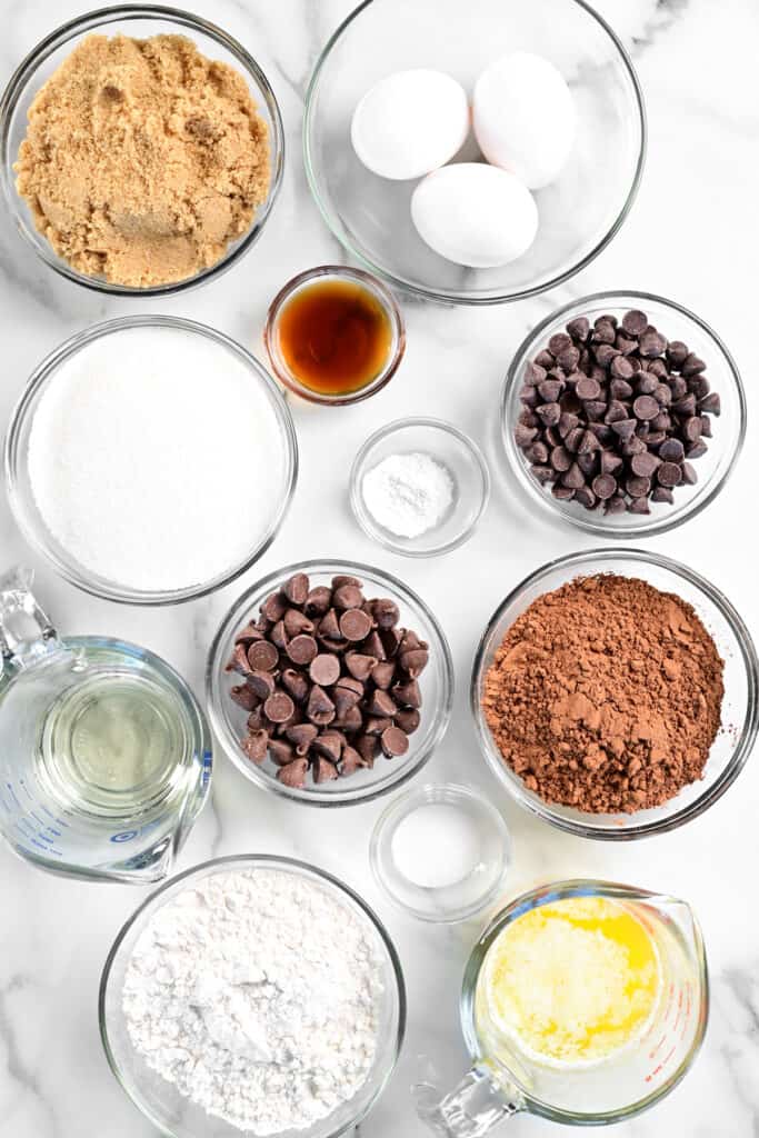 many ingredients for baking set out on a marble surface.
