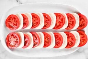 slices of tomato and mozzarella cheese laid out on a platter.
