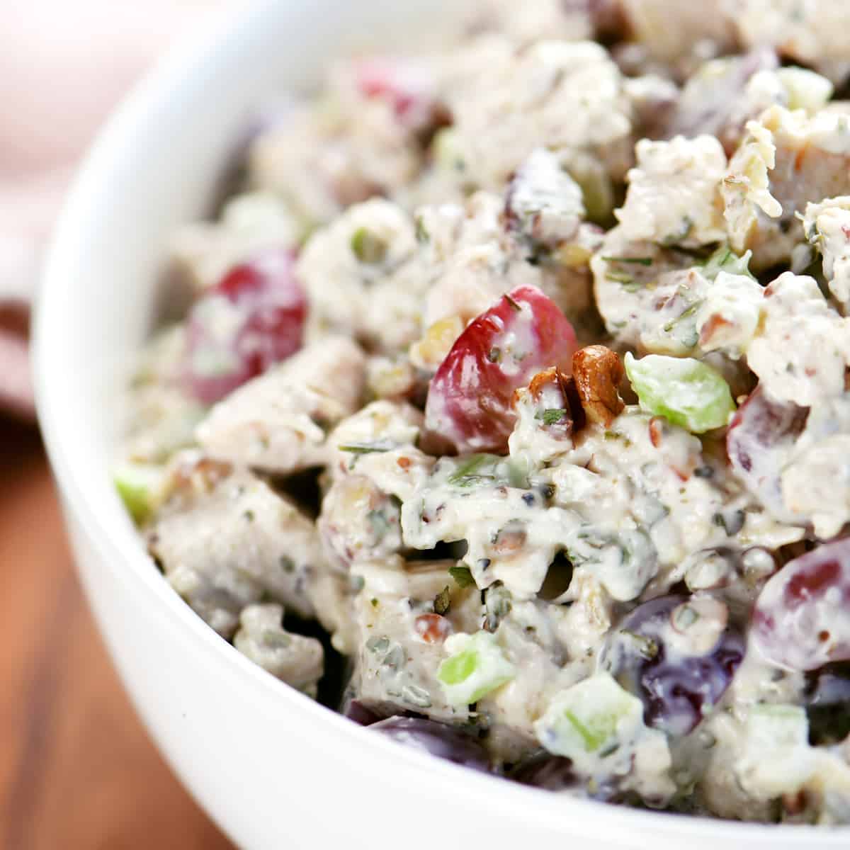 chicken salad in a white bowl with grapes.