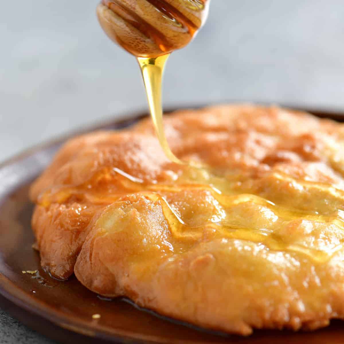 honey drizzling on a piece of fry bread.