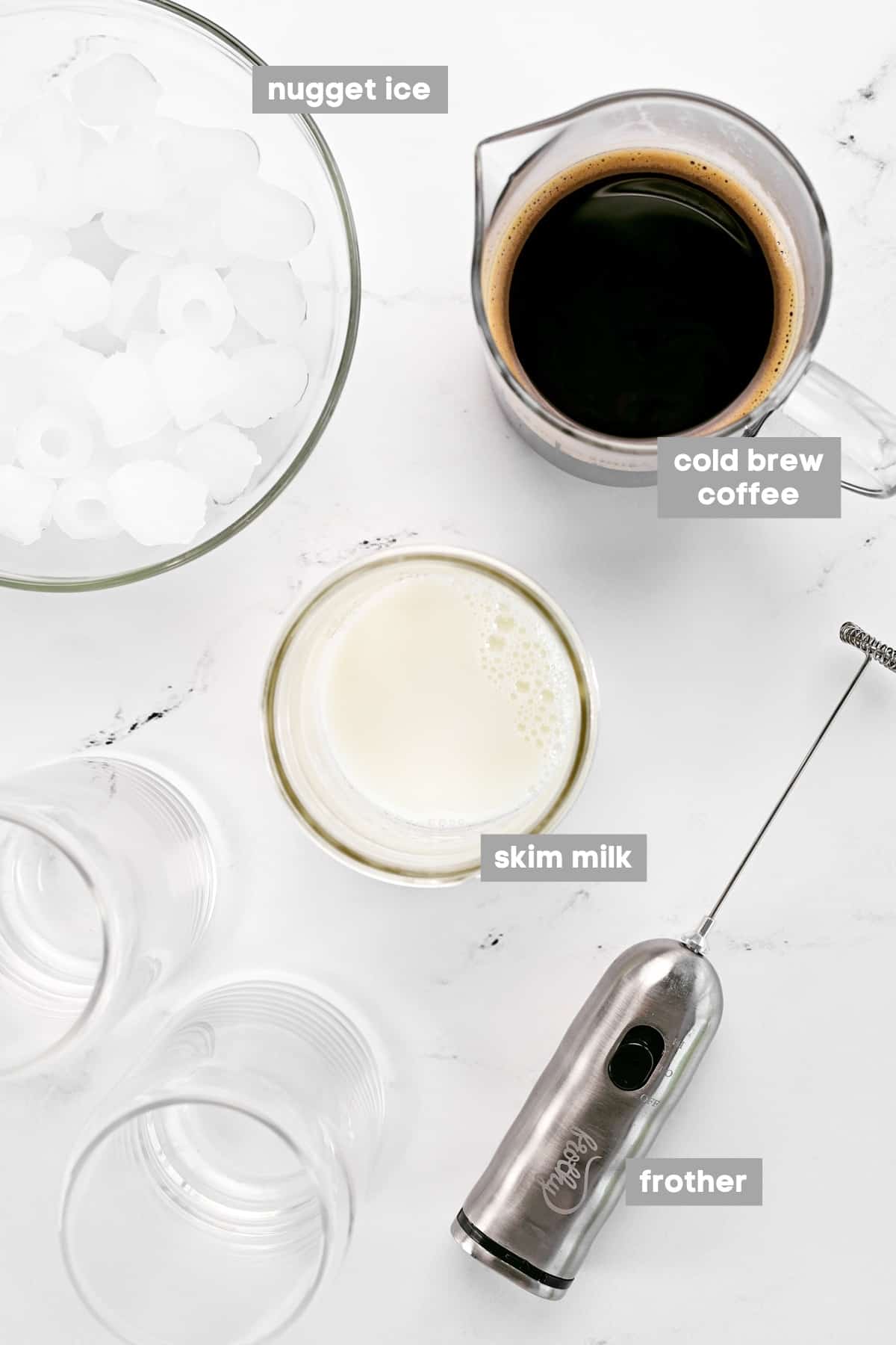 Ingredients in bowls, a frother, and two glasses.
