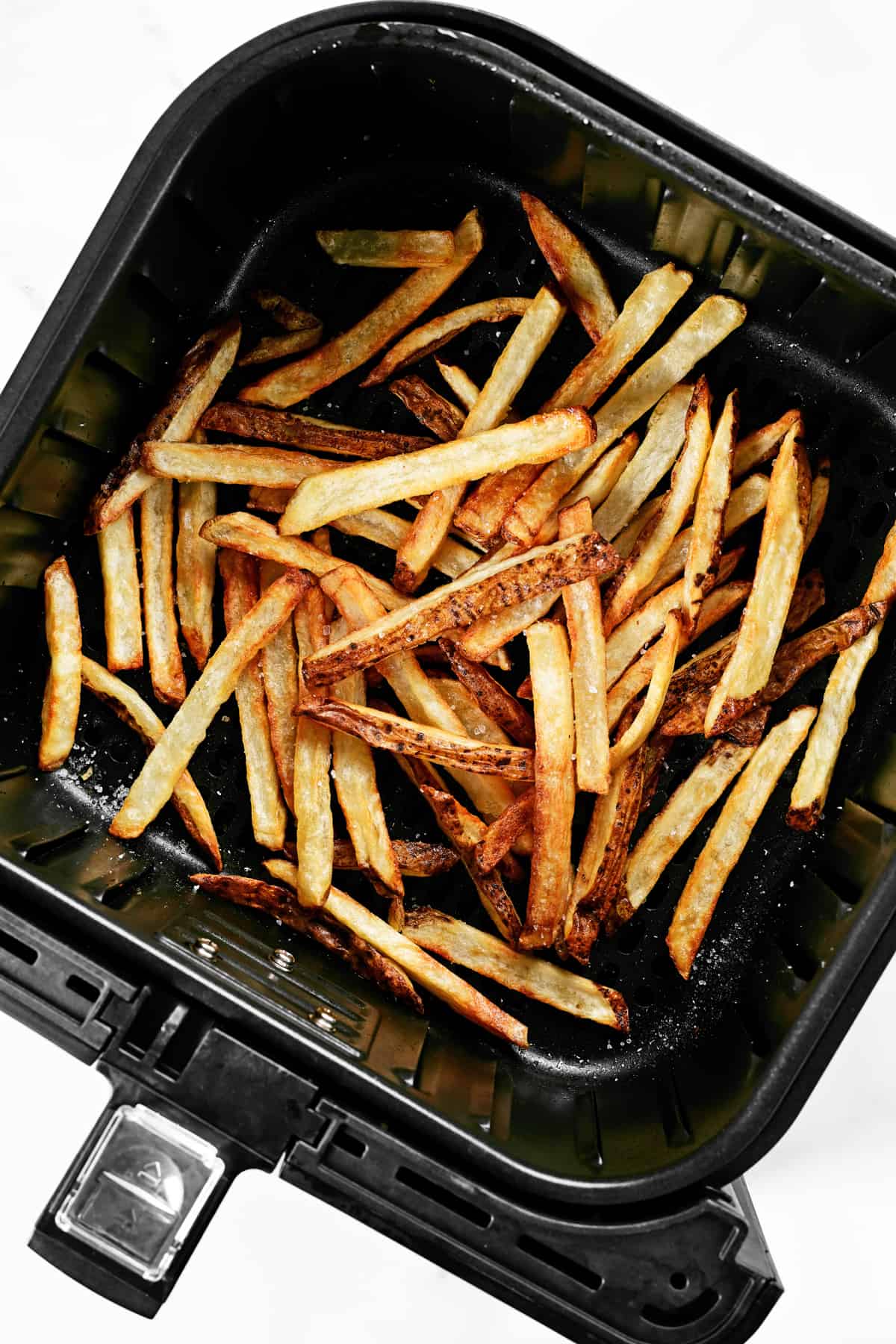 golden brown, crispy french fries in an air fryer basket.