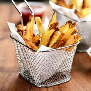 golden brown air fryer french fries in a small wire basket.