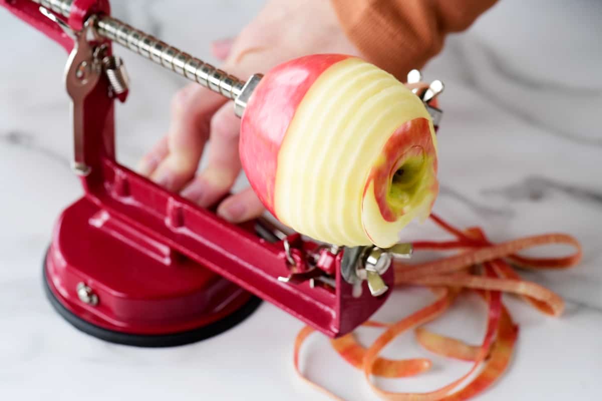 peeling an apple with a peel, corer, slicer tool.