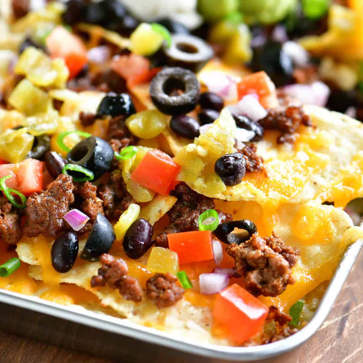 a metal tray of loaded nachos.