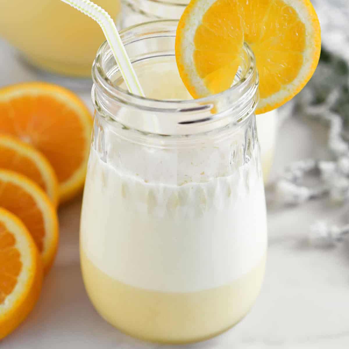orange whip in glasses with a straw and orange slices
