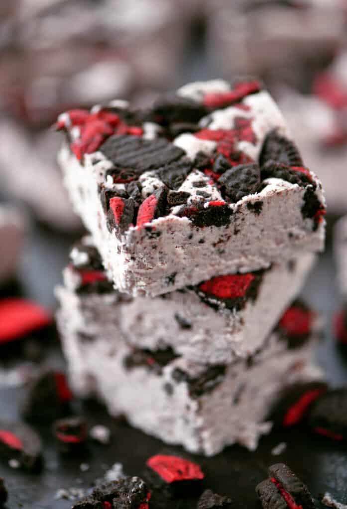 stack of three pieces of pink fudge with oreos on top.