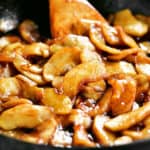 fried apples with cinnamon and caramelized brown sugar in a skillet.