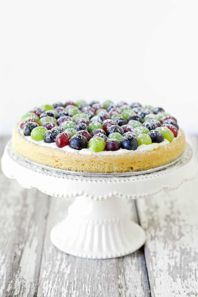 grape pizza on a white cake stand.