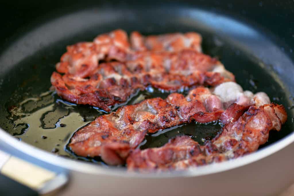 bacon frying in a saute pan