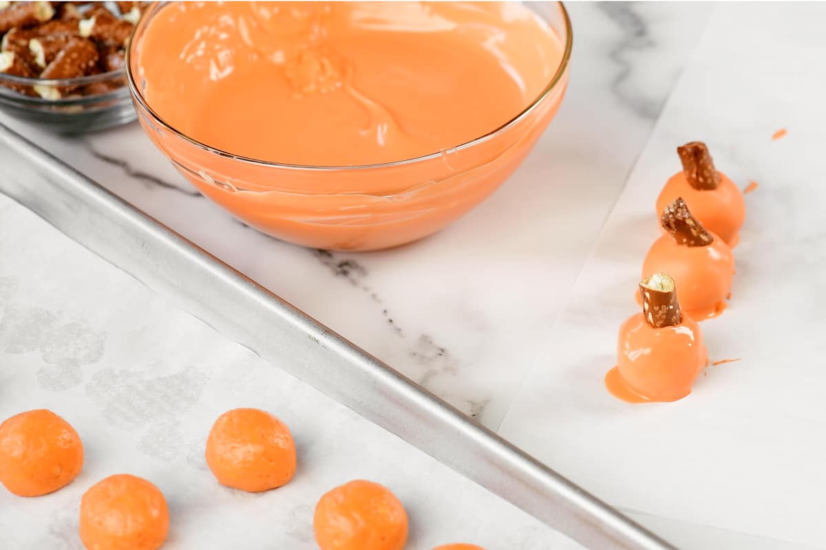 dipping orange oreo balls in candy coating and adding a pumpkin stem.