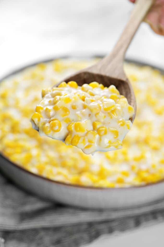 a wooden spoonful of creamy corn.