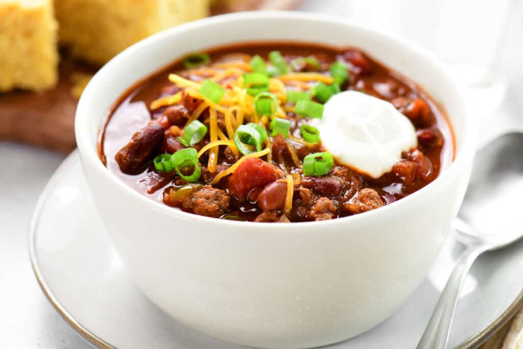 a white bowl with chili in it.