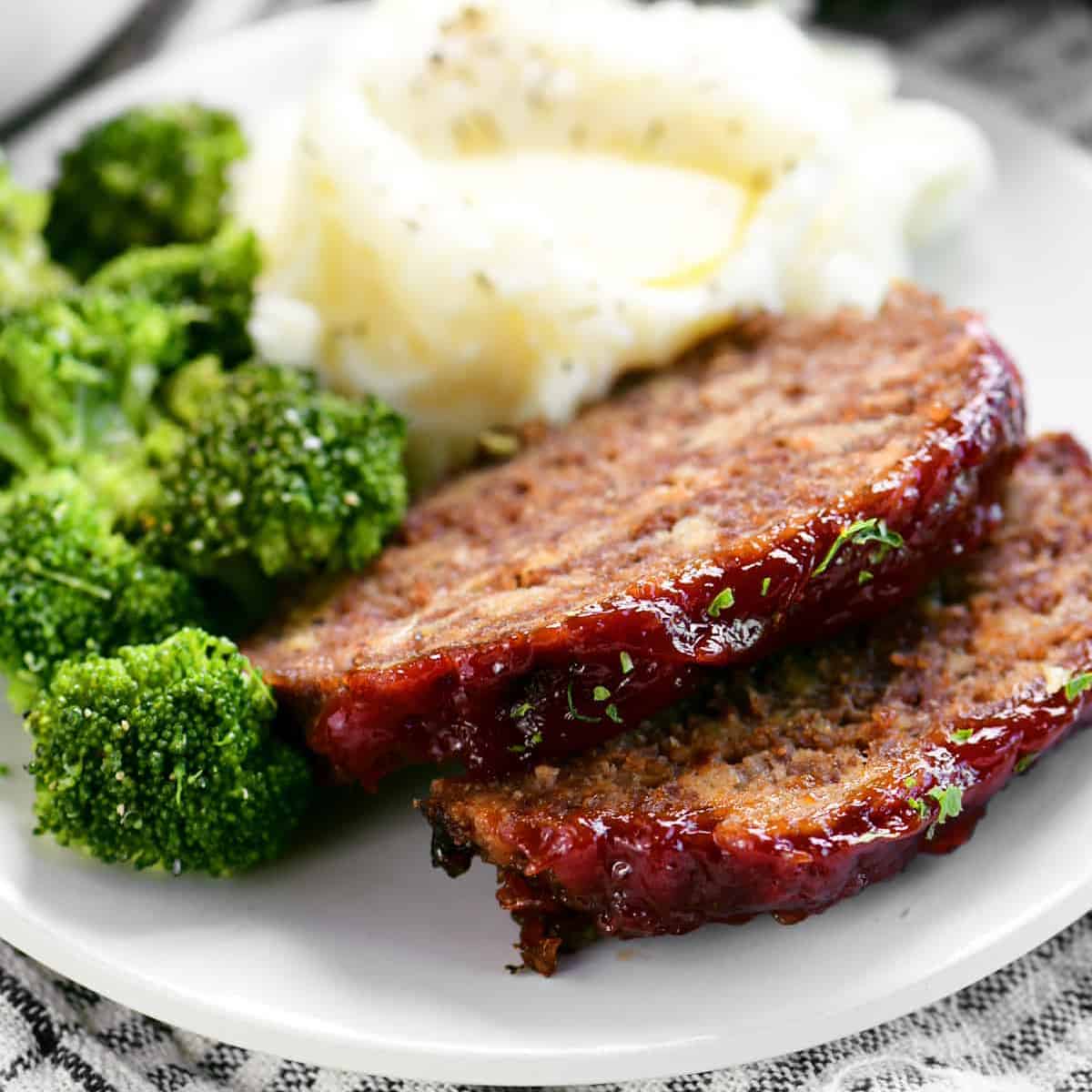 sliced meatloaf with mashed potatoes and broccoli.