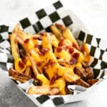 cheese fries with bacon bits on top.
