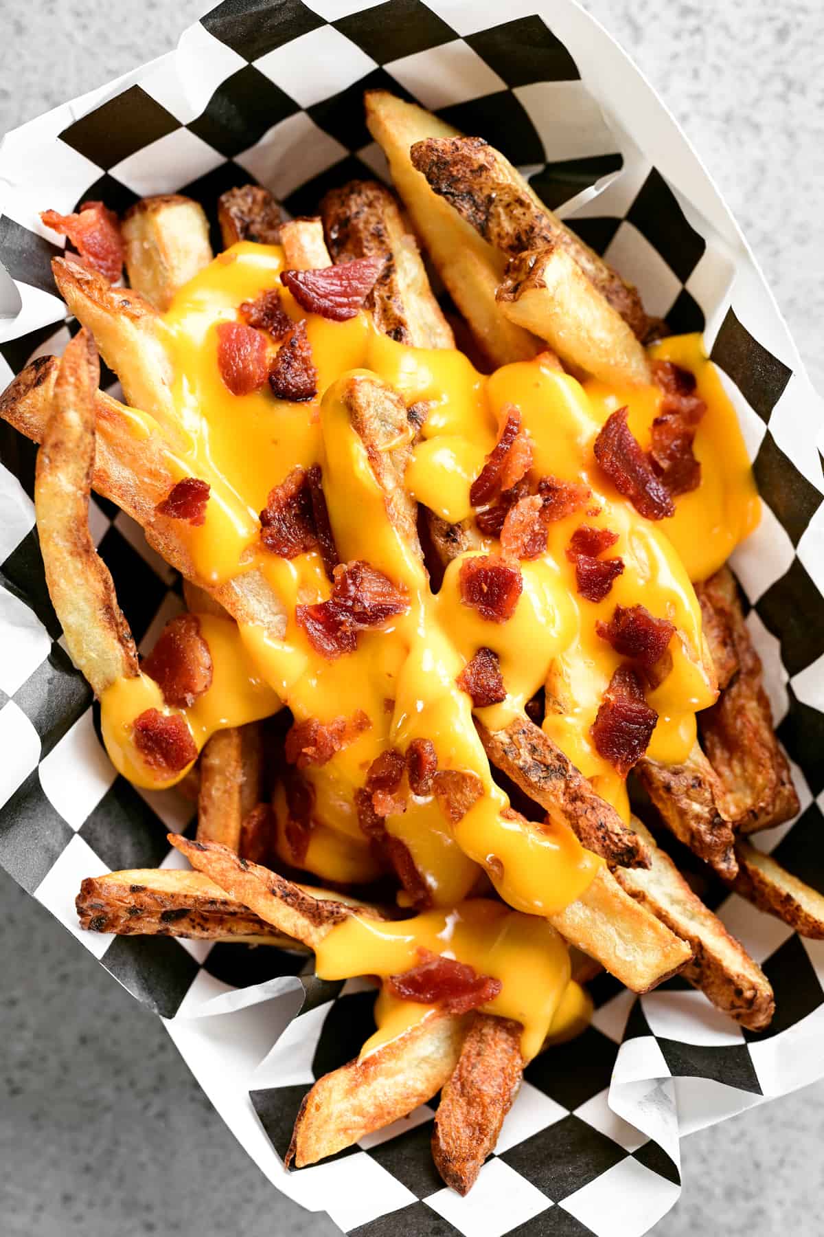 a paper basket filled with cheesy fries.