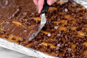 spreading melted chocolate chips over the toffee.