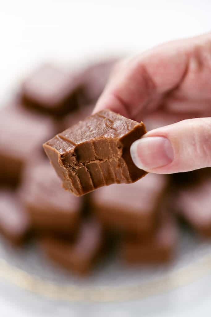 hand holding a piece of fudge with a bite removed.