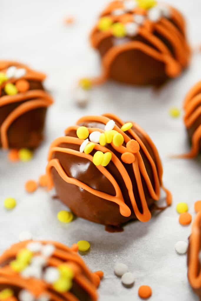 peanut butter balls with orange drizzle and spinkles.