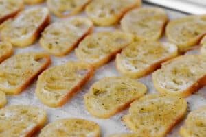 crostini slices laid out on a baking sheet.