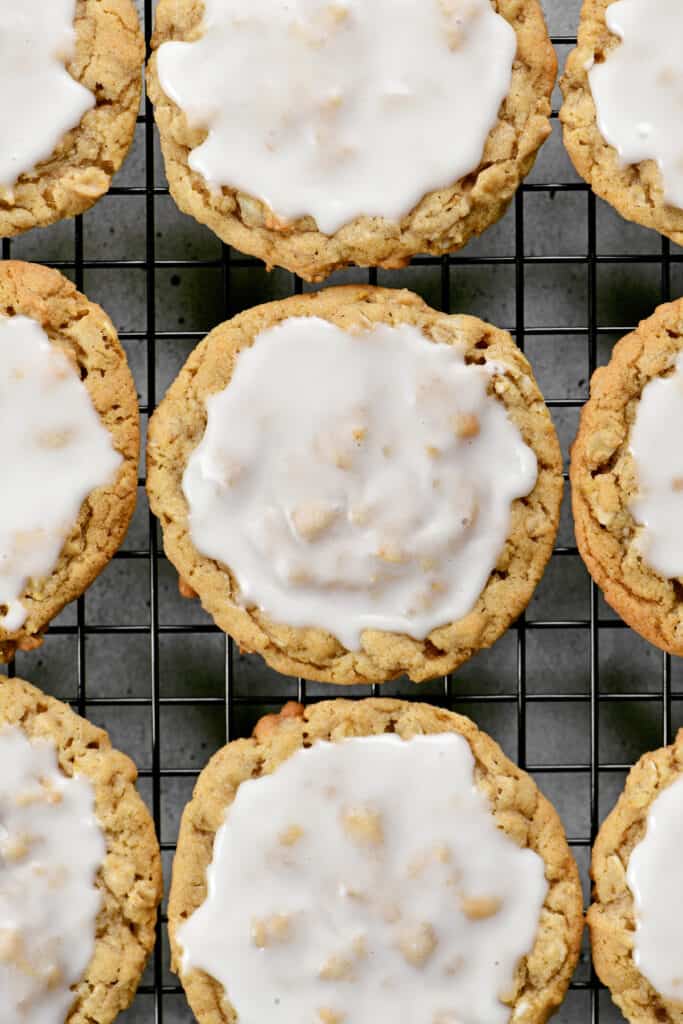 iced oatmeal cookies on a wire rack.