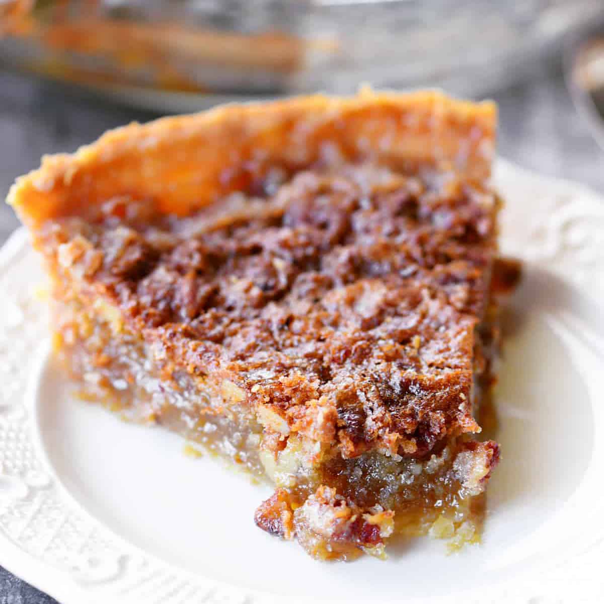 a slice of pecan pie on a white plate.