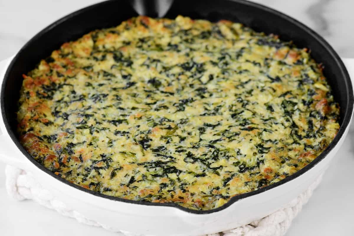 a full pan of cooked spinach dip.