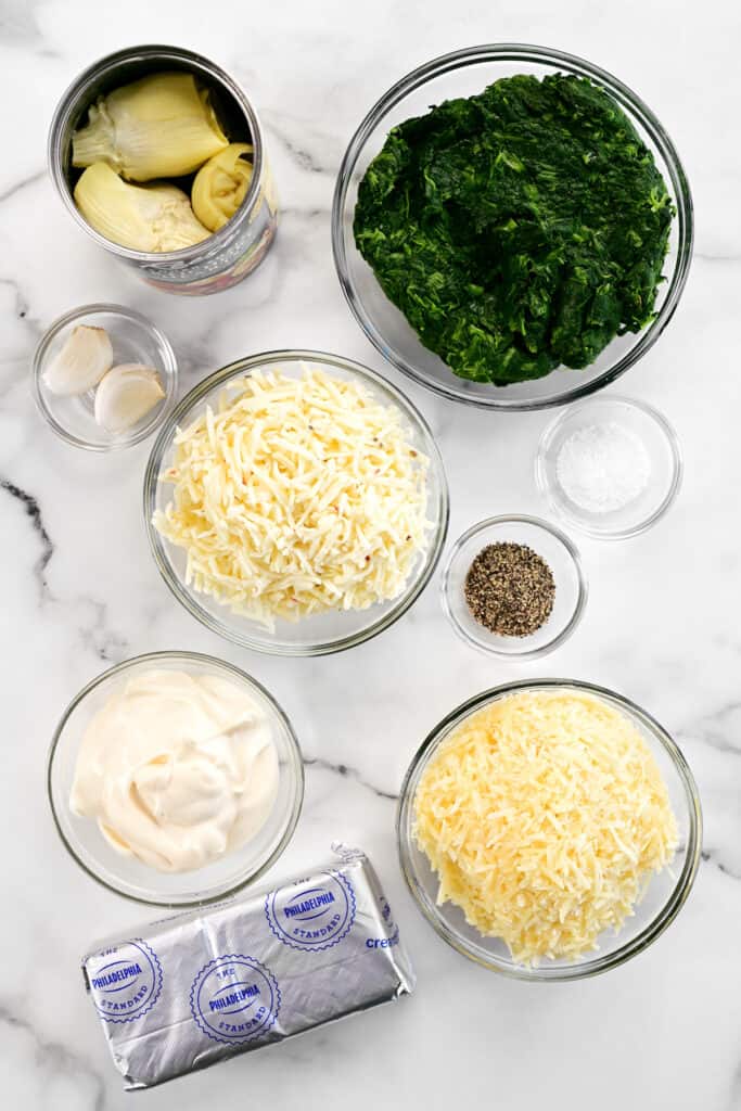 spinach artichoke dip ingredients set on a countertop.