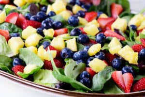 add blueberries, strawberries, and pineapple to salad.