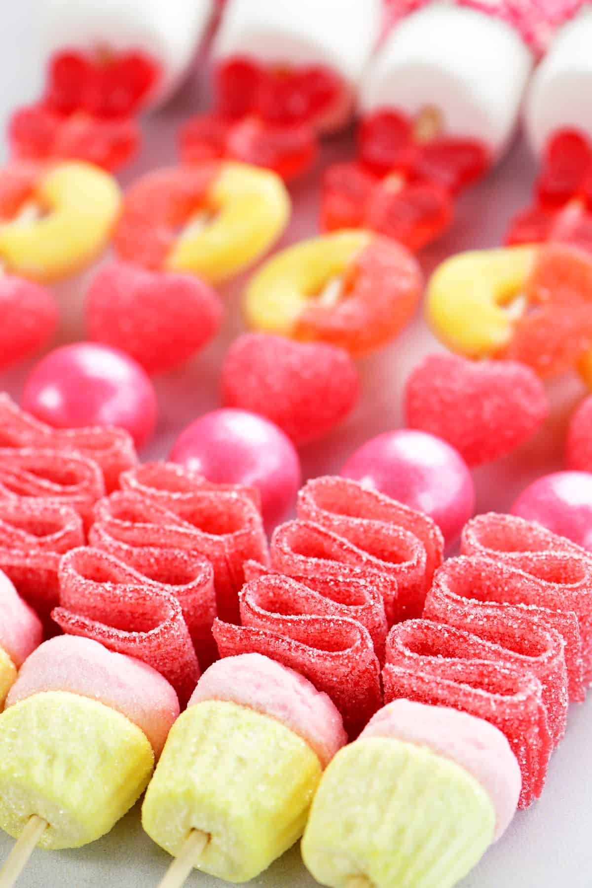 an assortment of colorful candies on wooden kabob sticks.