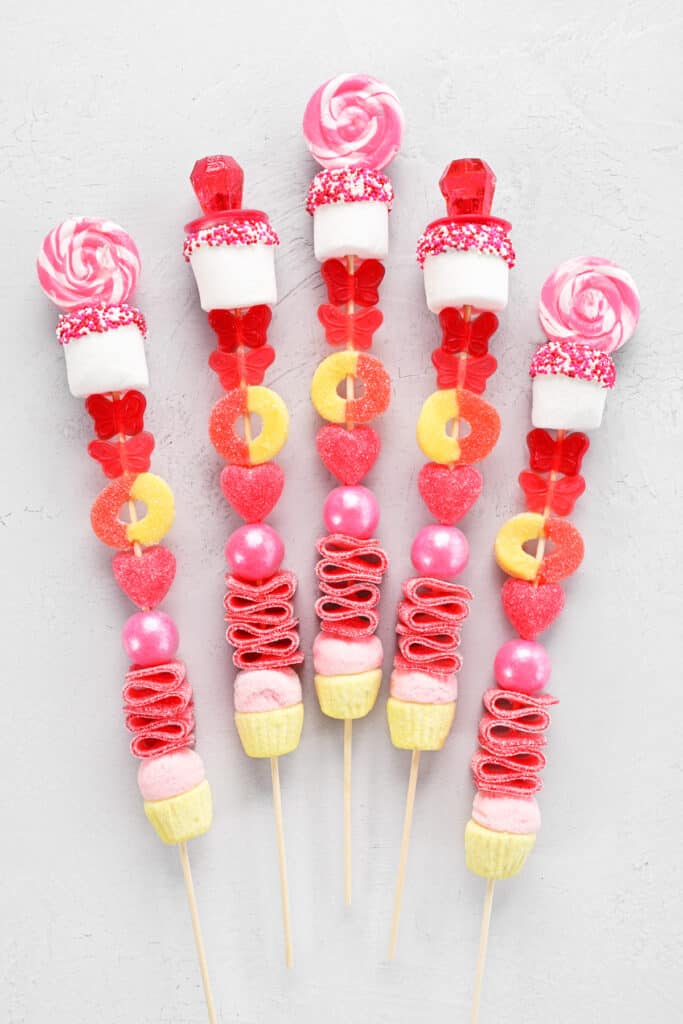 pink, yellow and red candies arranged on kabob sticks.