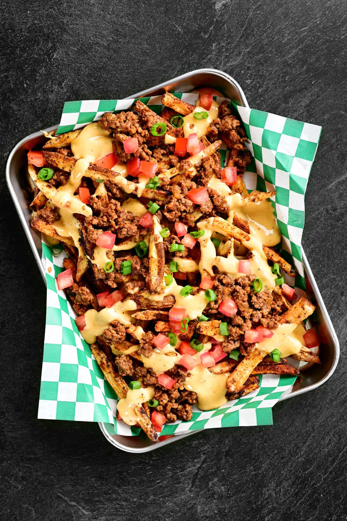 tray of loaded nacho fries with a green checked tray liner.