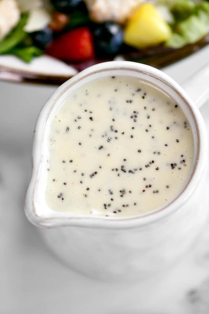top down view of poppy seed dressing in a white pitcher.