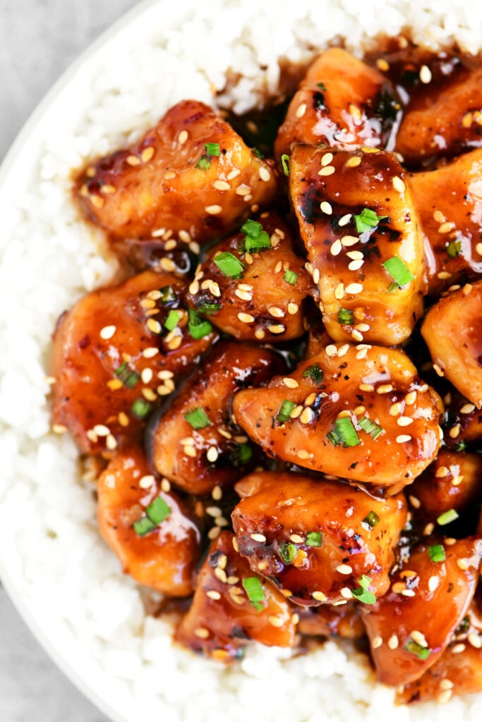 sesame chicken with sliced green onions on top.