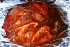 chicken breasts in bbq sauce in a slow cooker.