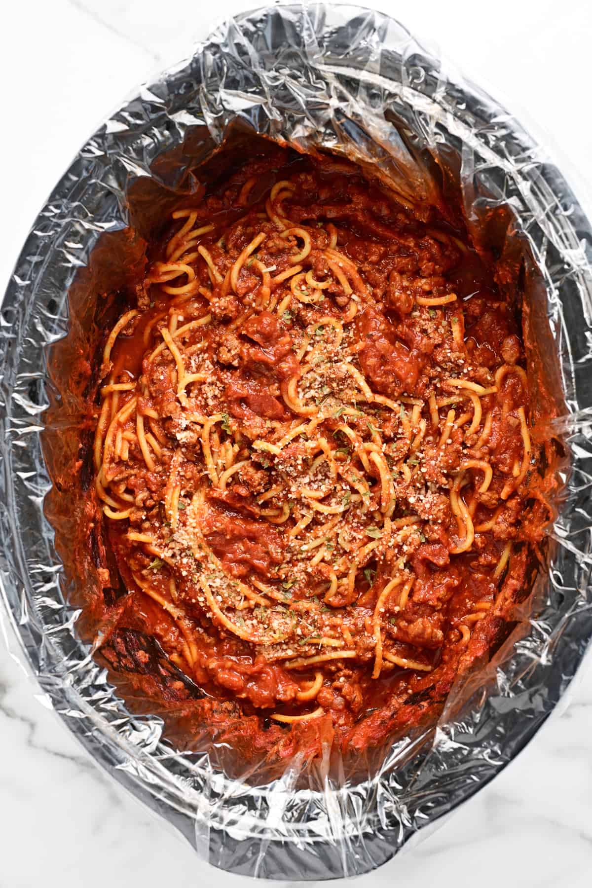 a slow cooker with a liner full of spaghetti.