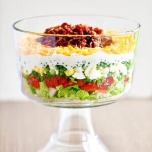 7 layer salad in a trifle dish.