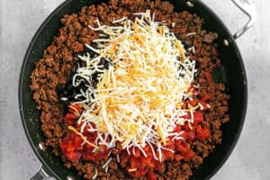 shredded cheese, tomatoes, and black beans added to meat in skillet.