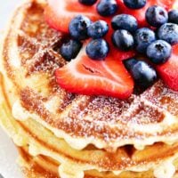 a stack of bisquick waffles with berries on top.