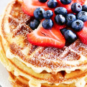 a stack of bisquick waffles with berries on top.
