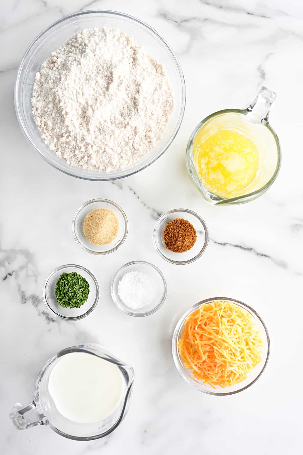 Ingredients in bowls on a white marble countertop.