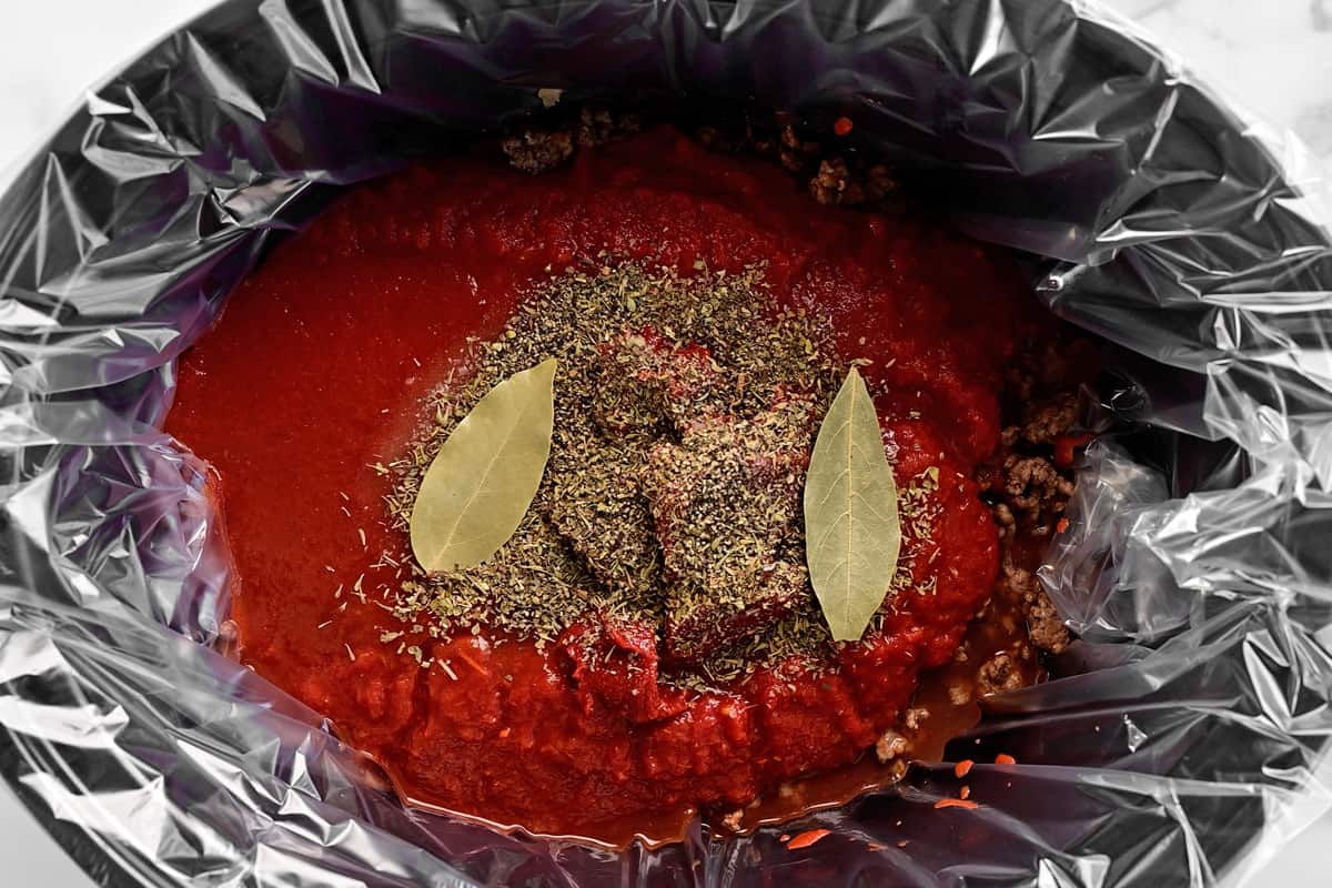 Red sauce, meat and spices in a slow cooker.