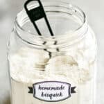 homemade bisquick in a mason jar with a black measuring cup.