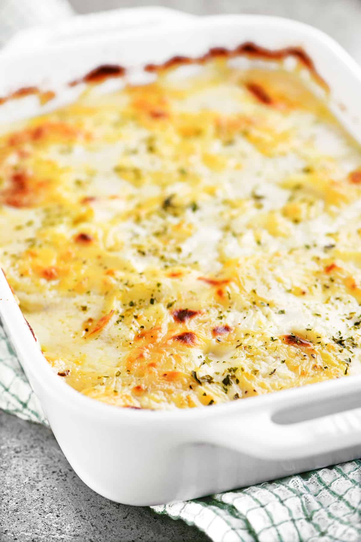 Casserole dish of cooked scalloped potatoes.