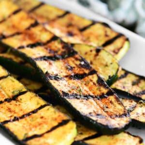 grilled zucchini on a white platter.