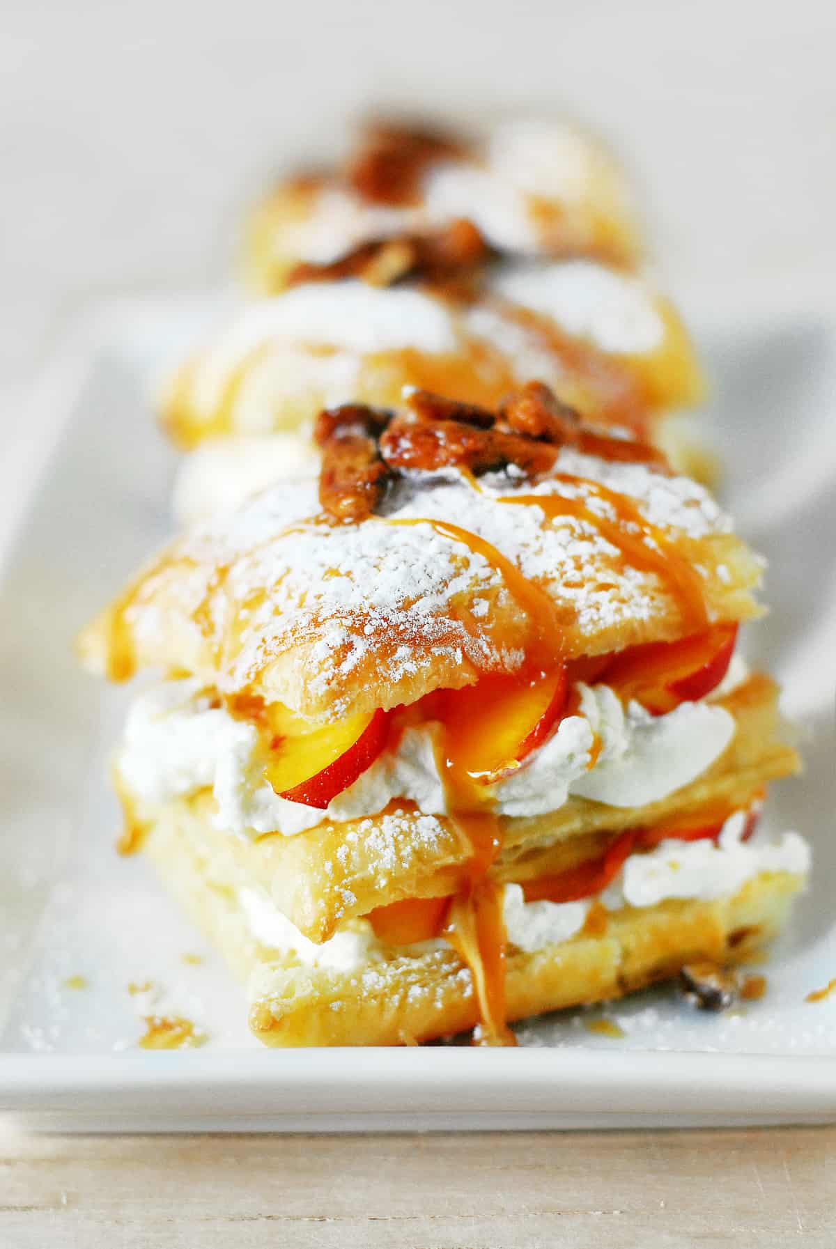 Napoleon recipe with whipped cream and sliced peaches.