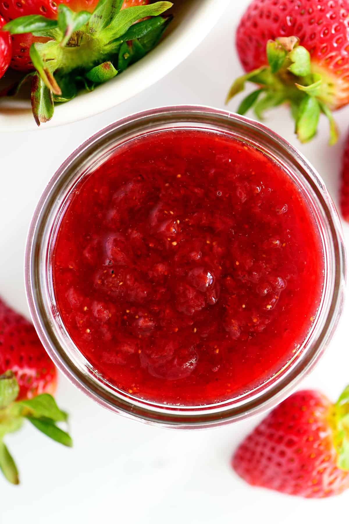 Strawberry glaze in a small glass jar.