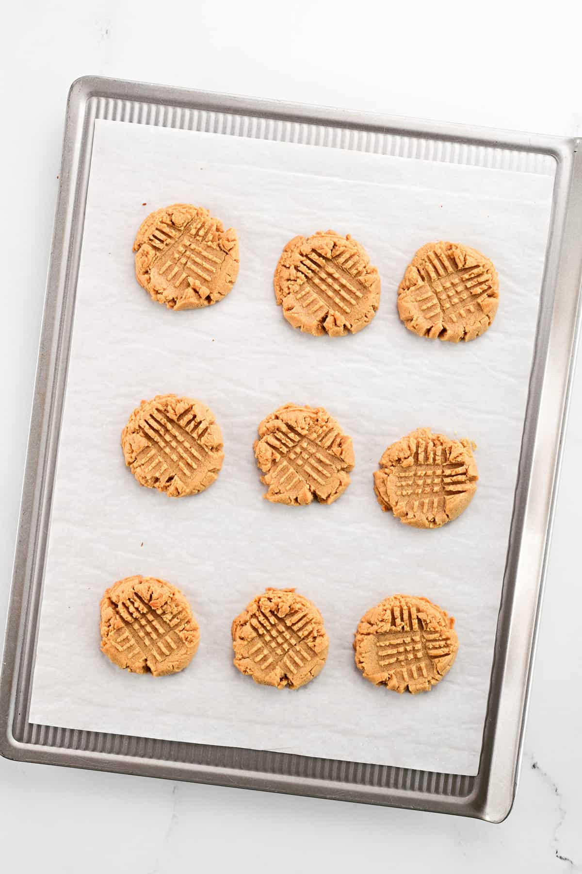 Four-ingredient peanut butter cookies on a baking sheet.