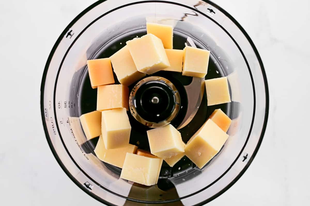 Cubes of parmesan cheese in a food processor.